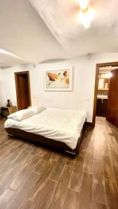 Cama en habitación con suelo de madera en Ultracentral Apartment en Arad