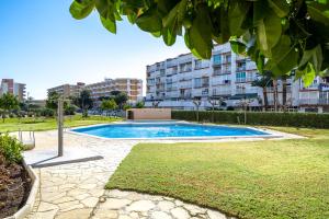 una piscina en un parque con edificios al fondo en Salou Beach 1 en La Pineda