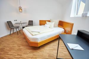 una camera con letto, tavolo e sedie di ERCK- Flair Hotel & Restaurant a Bad Schönborn