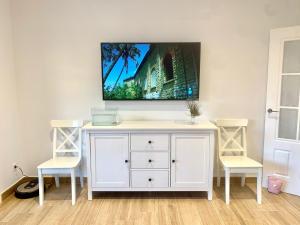 克莉絲蒂娜島的住宿－Islantilla Luxury，白色娱乐中心,配有两把椅子和墙上的电视