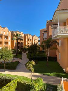 克莉絲蒂娜島的住宿－Islantilla Luxury，公寓大楼拥有棕榈树和小径。
