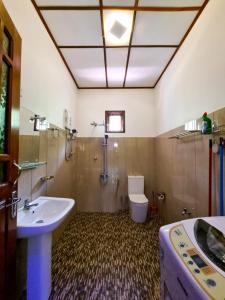 ein Bad mit einem Waschbecken und einem WC in der Unterkunft Ivory Bloom Resort in Diyatalawa