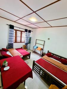 a living room with two beds and red sheets at Ivory Bloom Resort in Diyatalawa