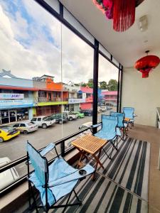 balcón con sillas azules y vistas a la calle en Amazing Rooms en Semporna