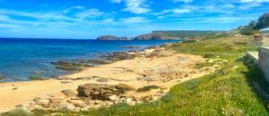 a beach with rocks and the ocean in the background at Mura Guest Room in Terralba