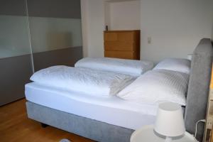 2 camas con sábanas blancas y una lámpara en una habitación en Appartement Bärhof en Innsbruck