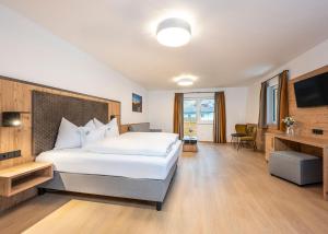 ein Hotelzimmer mit einem Bett und einem TV in der Unterkunft Hotel Brunner - Reiteralm in Schladming