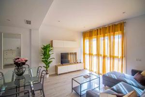 ein Wohnzimmer mit einem Tisch und einem Sofa in der Unterkunft New Apartamento centro de Torremolinos con Parking in Torremolinos