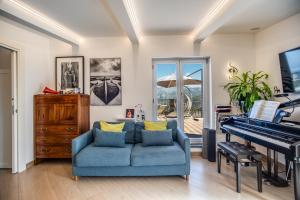 uma sala de estar com um sofá azul e um piano em VILLA CARUSO PRIVATE HEATED POOL & SEA VIEW em Sorrento