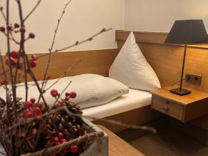 a bedroom with a bed and a table with a lamp at Landschaftsgasthaus Schanze 1 in Schmallenberg