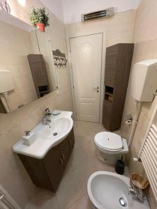 een badkamer met een wastafel, een toilet en een spiegel bij Aria di mare in Sanremo