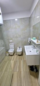 uma casa de banho com dois lavatórios e um WC em Arkle Apartment 5 em Tirana