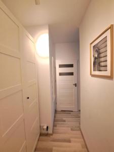 korytarz z białymi drzwiami i światłem w obiekcie Hey Stay Apartment with private garden w Toruniu