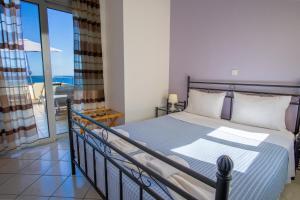 sypialnia z łóżkiem i balkonem z widokiem na ocean w obiekcie Blue Villas w mieście Agia Marina Nea Kydonias +37 zdjęć