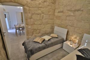 ein Schlafzimmer mit einem Bett und einer Steinwand in der Unterkunft Rebecca historic residence in Otranto in Otranto