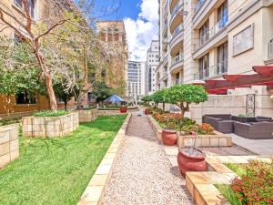 a garden with trees and plants in a city at Apartment at Michelangelo Towers in Johannesburg