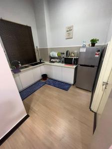 a small kitchen with a refrigerator and a wooden floor at VH Homes, Imago Shopping Mall in Kota Kinabalu