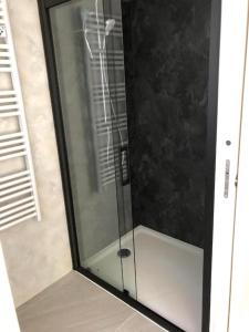 y baño con ducha y puerta de cristal. en Gîte du Travers en Sébrazac