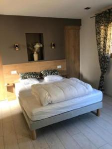 1 dormitorio con 1 cama grande y cabecero de madera en Gîte du Travers en Sébrazac