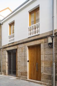a building with a wooden door and windows at La Fonda in Pontevedra