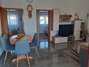 a living room with a table and chairs and a television at Apartments Lora in Vir