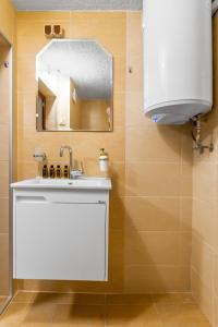 a bathroom with a white sink and a mirror at The Secret Spot 1BD Apartment in Sofia