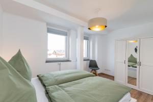 Un dormitorio con una cama verde y una ventana en EASYLIFE - Apartment Balance, en Eisenach