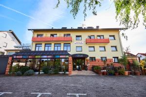 a large yellow building with a store front at ERCK- Flair Hotel & Restaurant in Bad Schonborn