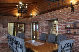 a dining room with a brick wall and a wooden table and chairs at Dobranić - Kuća za odmor in Sveti Martin na Muri
