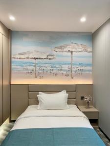 a bedroom with a painting of a beach with umbrellas at Fan's Hotel- Ormoc in Ormoc