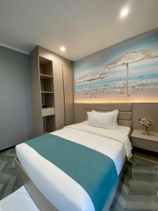 a bedroom with a large bed and a painting of a beach at Fan's Hotel- Ormoc in Ormoc