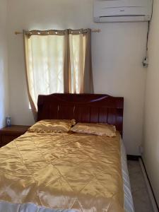 Bett in einem kleinen Zimmer mit Fenster in der Unterkunft Shero Villa in Flic-en-Flac
