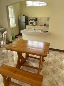 a kitchen with a wooden table and a bench at Shero Villa in Flic-en-Flac
