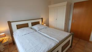 um quarto com uma cama com lençóis brancos e uma porta em Wohnen im orientalischen Ambiente em Harthausen
