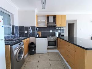 a kitchen with a sink and a dishwasher at The Aqua - Sleeps 4 - Patio & Sea Views in Plettenberg Bay