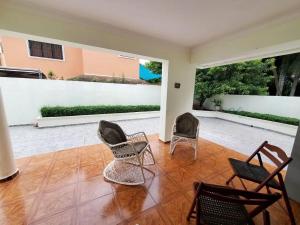 sala de estar con sillas y patio en Villa Isabel, villa entera, piscina, cerca embajada USA en Santo Domingo
