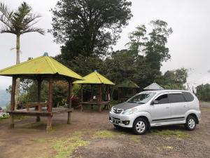 佩母得蘭的住宿－草堂新都旅館，一辆停在野餐桌前的白色汽车