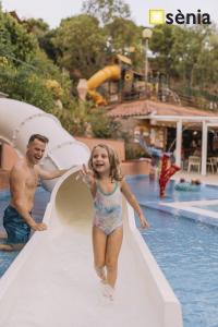 a young girl walking down a slide at a swimming pool at Albatross Mobile Homes on Camping Cala Canyelles in Lloret de Mar