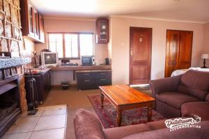 a living room with a couch and a table at Duckling Cottage in Dullstroom