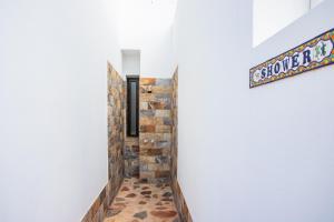 a hallway with a brick wall and a sign on a wall at Casa Maurizio - Heated Pool, Hot Tub & Hammam in Playa Blanca