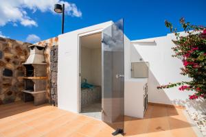 a kitchen with a glass door and a refrigerator at Casa Maurizio - Heated Pool, Hot Tub & Hammam in Playa Blanca