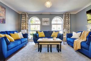 Sala de estar con sofás azules y mesa de centro en 14 Oxford Mews - 5 Star Living for up to 10 People, en Southampton