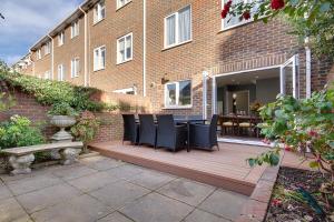 a deck with chairs and a table in front of a building at 14 Oxford Mews - 5 Star Living for up to 10 People in Southampton