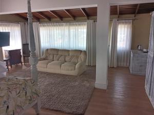 ein Wohnzimmer mit einer weißen Couch in einem Zimmer in der Unterkunft Pedro Barn in Nuwara Eliya