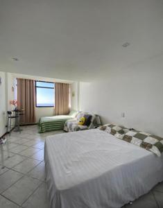 a hotel room with a large bed and a couch at Apartamento Vista Mar Salvador - Vista fantástica in Salvador