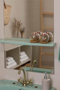 baño con lavabo y estante con magdalenas en a casa da Alicia, en Monforte de Lemos