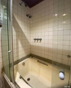 y baño con bañera y ducha acristalada. en Apartamento Vista Mar Salvador - Vista fantástica, en Salvador