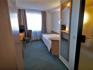 Postel nebo postele na pokoji v ubytování Hotel Goldener Hirsch Mosbach