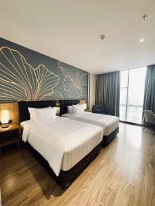 a hotel room with two beds and a painting on the wall at Grand Central Premier in Medan