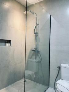 a glass shower in a bathroom with a toilet at Grand Central Premier in Medan